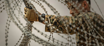 Member of Military using 212 Performance gloves to deploy razor wire